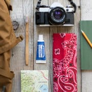 Travel-size toothpaste next to a camera and a map