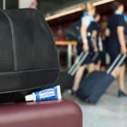 Travel-size toothpaste next to a bag