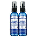 Two blue 2 fl oz bottles of Dr. Bronners Peppermint Organic Hand Sanitizer with spray tops, labeled as certified fair trade. Text reads FAMILY SOAPMAKERS SINCE 1858, PEPPERMINT ORGANIC HAND SANITIZER, CERTIFIED FAIR TRADE, and ALL ONE Ideal for eco friendly hygiene